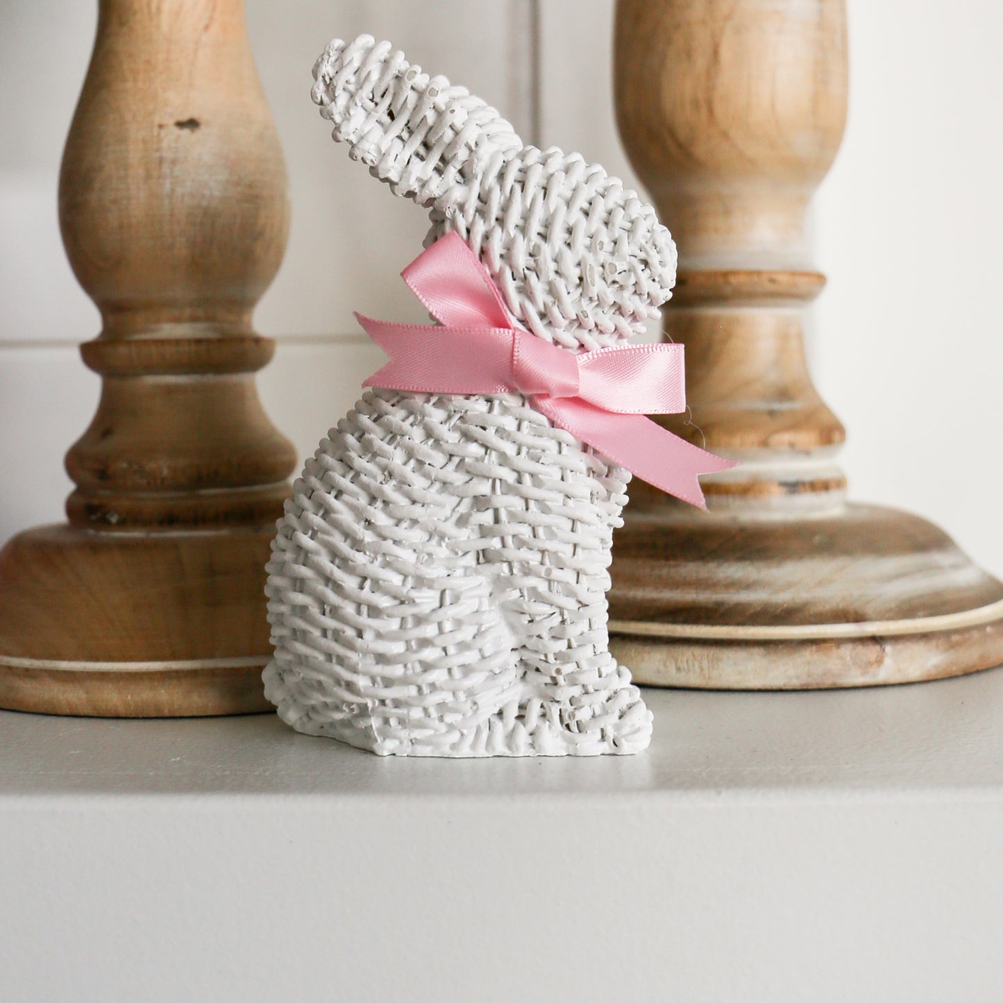 White Woven Wicker Bunny with Bow Standing by Stairs